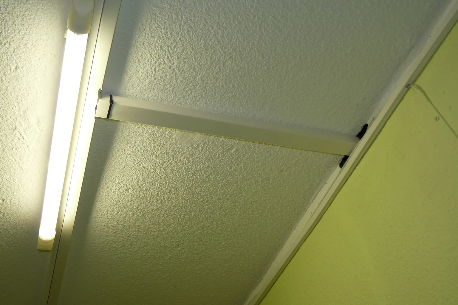Kabel wird in einem weißen PVC-Installationskanal entlang einer Wand geführt; der Kanaldeckel ist geöffnet und der Leitungsverlauf ist sichtbar