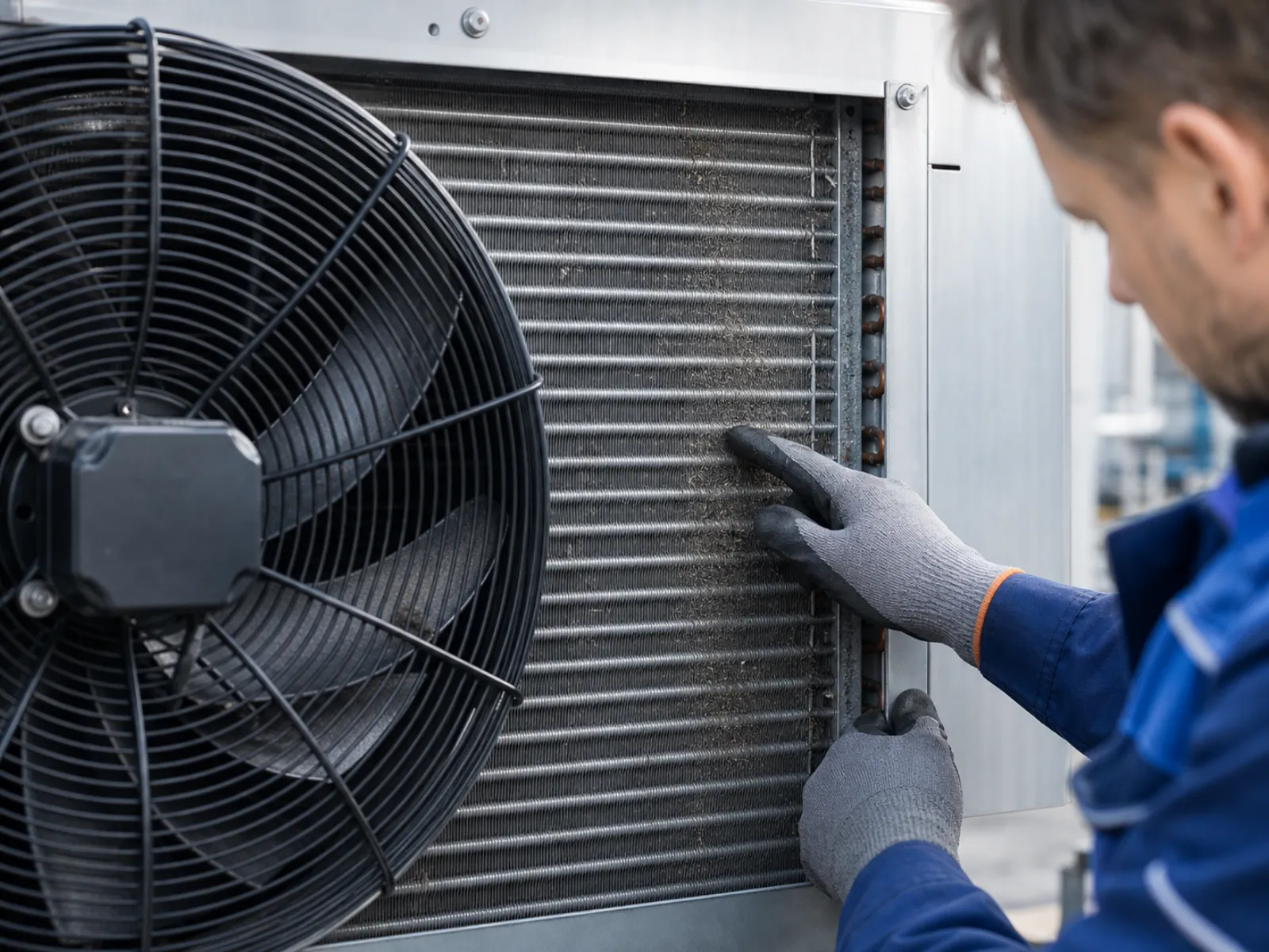 Außeneinheit einer Kälteanlage mit sichtbaren Verflüssigerlamellen und Ventilatoren, die auf Verschmutzung geprüft werden