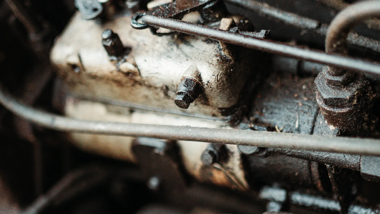 Nahaufnahme einer beanspruchten mechanischen Baugruppe mit Leitungen und Verbindungselementen in industrieller Umgebung