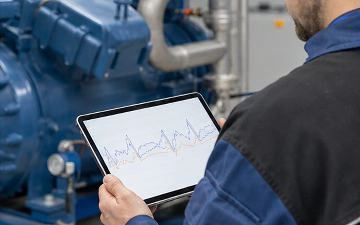 Techniker analysiert Temperatur- und Drucktrends an einer Industriekälteanlage